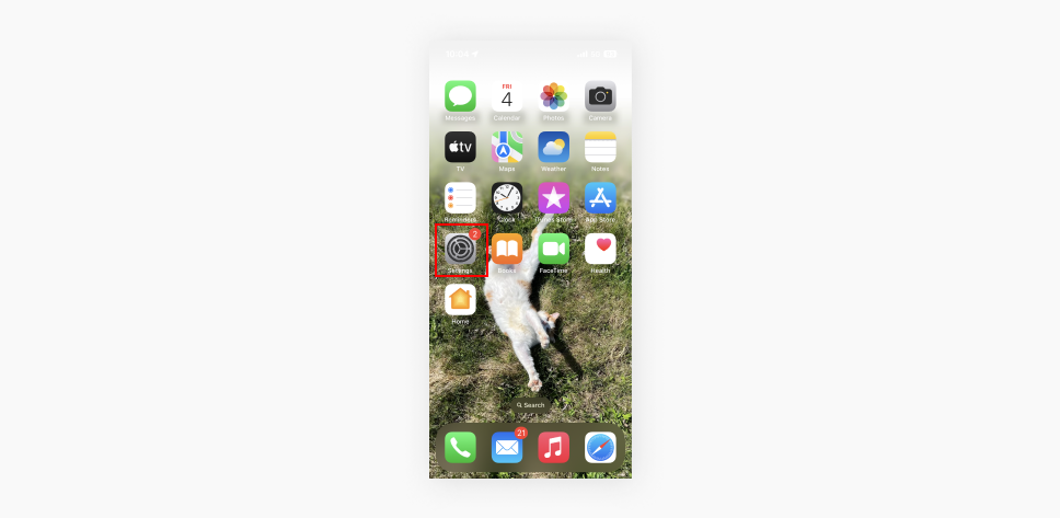 A screenshot showing the home screen of an iOS device, with the Settings app icon highlighted, ready to be selected.